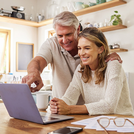 A couple smiling while looking at a computer screen