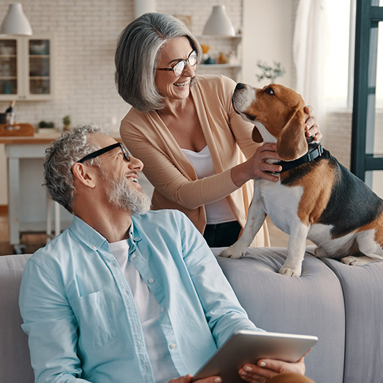 Older couple smiling at their dog